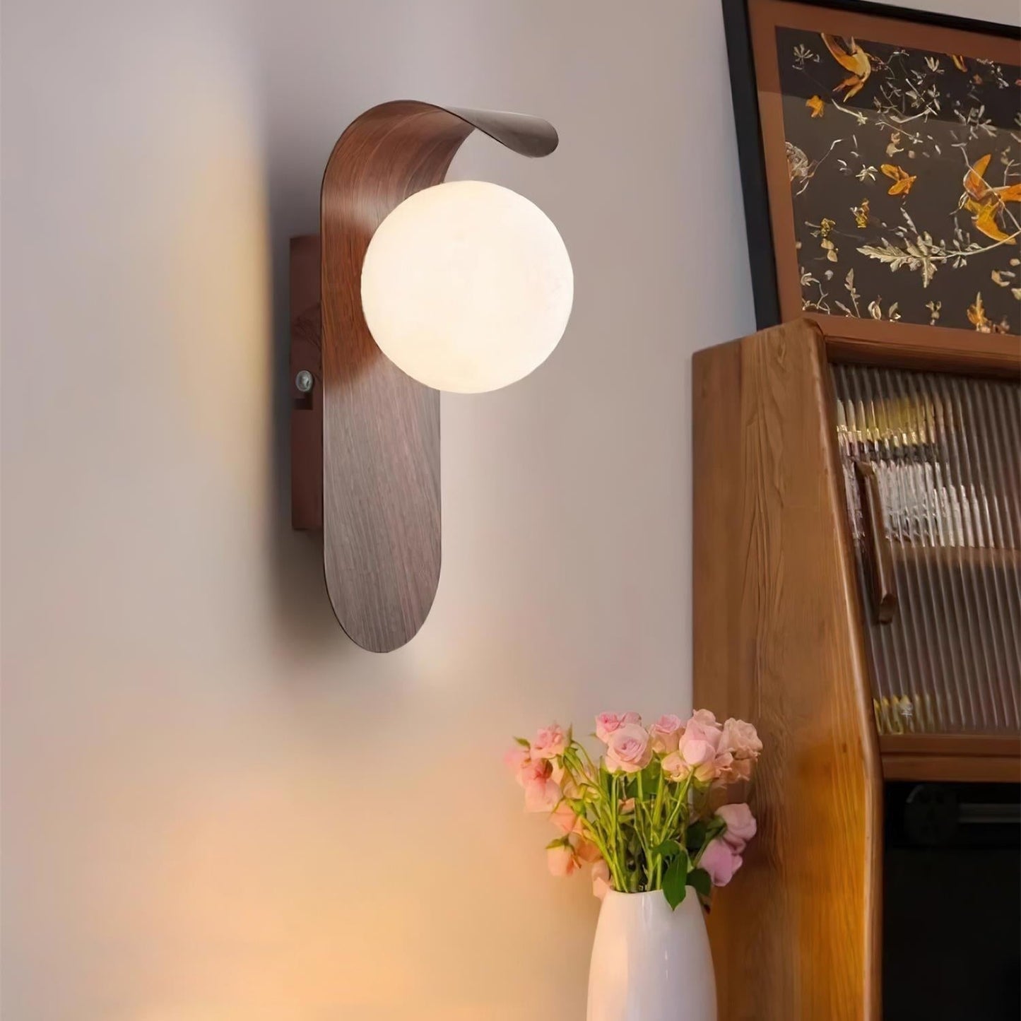 nordisk vägglampa med träinspirerad stomme och rund glasglob för varm och mjuk belysning