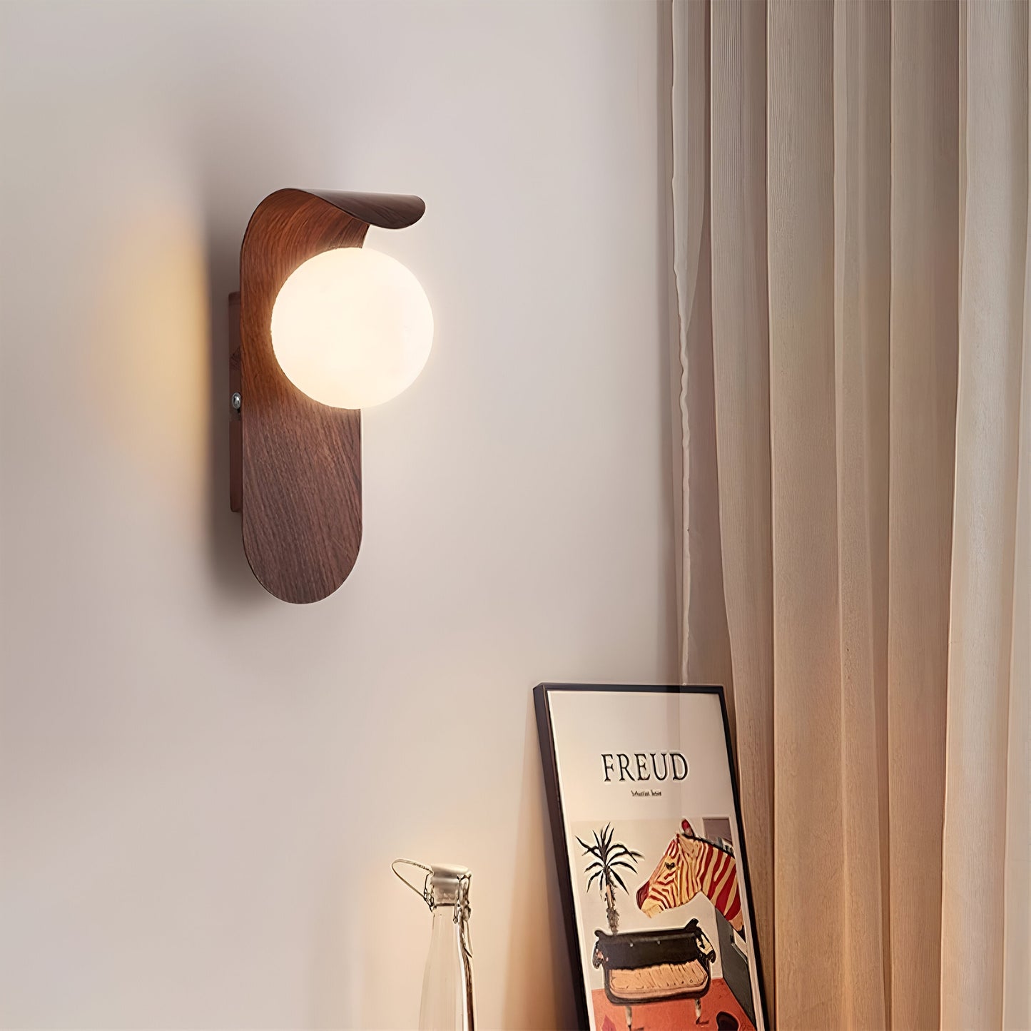 nordisk vägglampa med träinspirerad stomme och rund glasglob för varm och mjuk belysning
