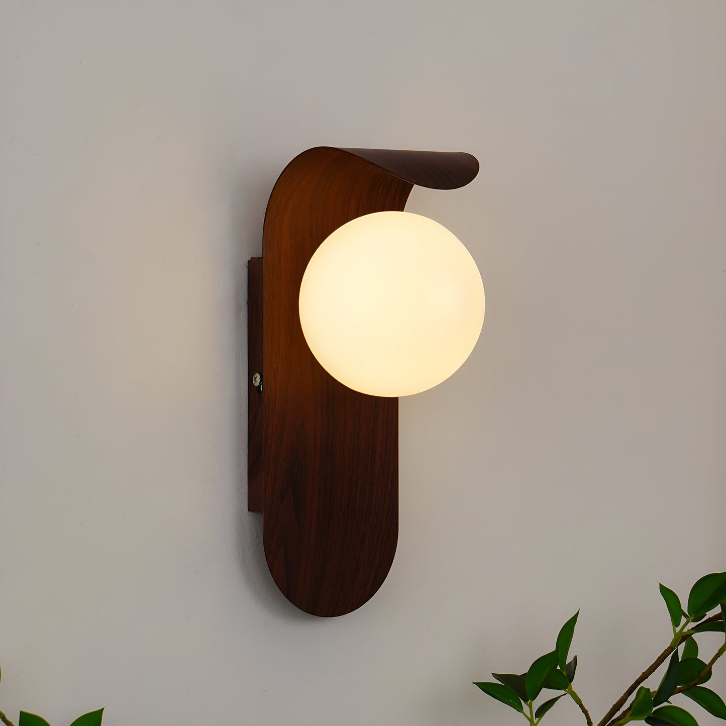 nordisk vägglampa med träinspirerad stomme och rund glasglob för varm och mjuk belysning