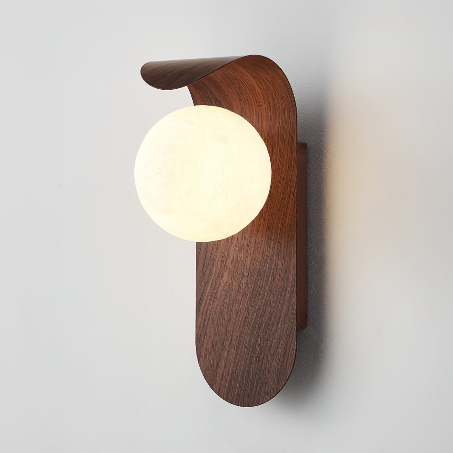 nordisk vägglampa med träinspirerad stomme och rund glasglob för varm och mjuk belysning