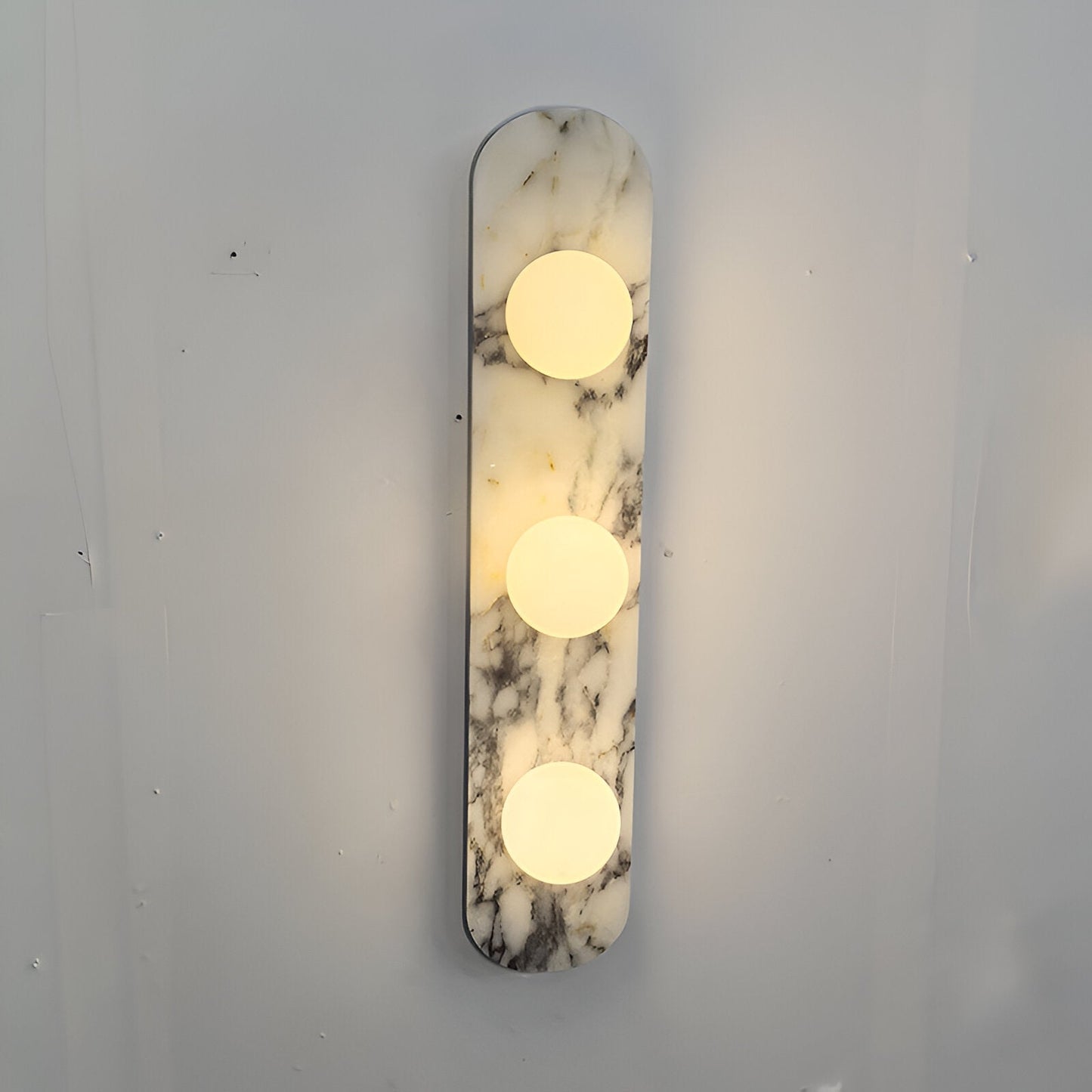 exklusiv vägglampa i naturlig marmor med runda glaskupor för modern och lyxig inredning