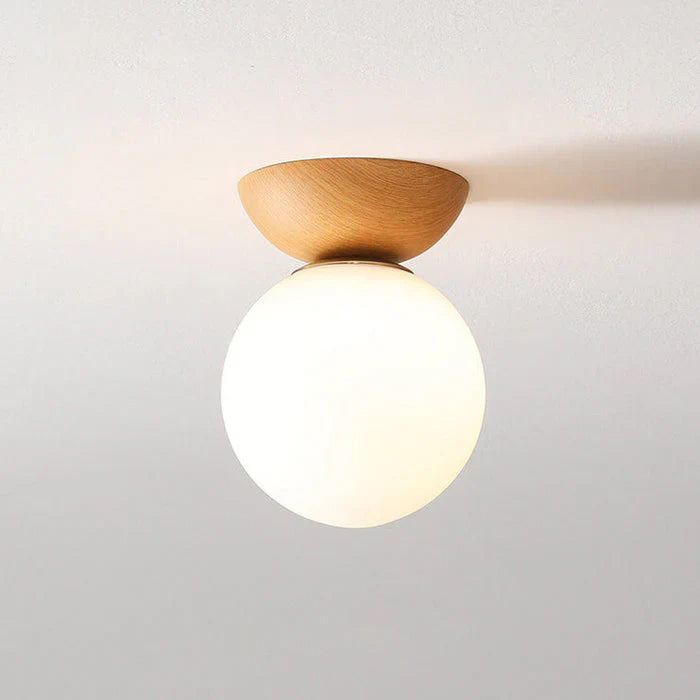 taklampa med rund opal glaskupa och naturlig träsockel för varm och mjuk belysning