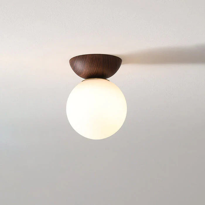 taklampa med rund opal glaskupa och naturlig träsockel för varm och mjuk belysning
