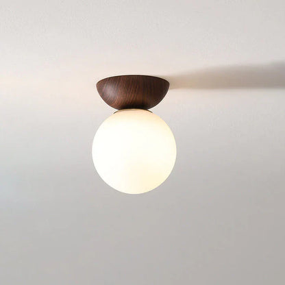 Taklampa med rund opal glaskupa och naturlig träsockel för varm och mjuk belysning
