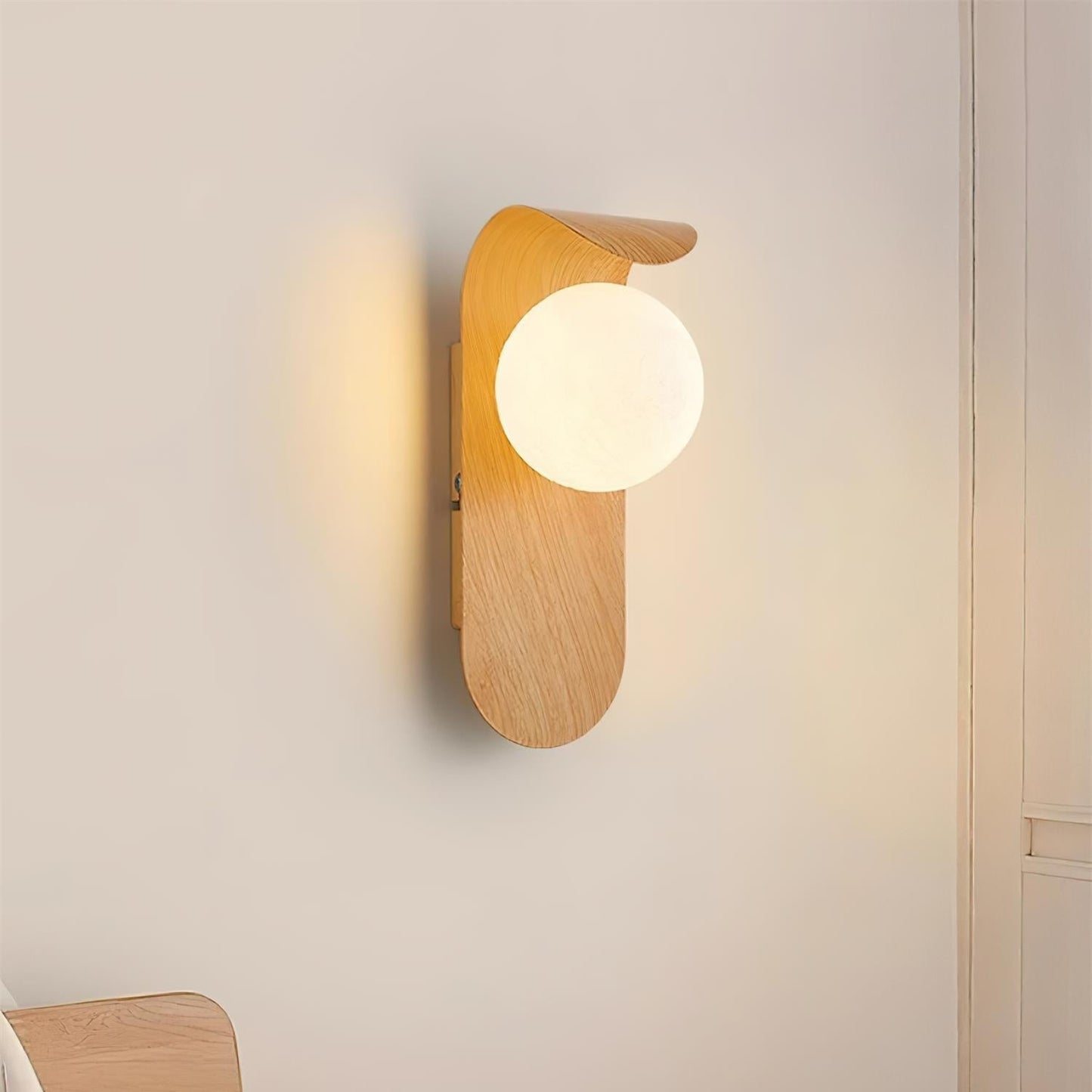 nordisk vägglampa med träinspirerad stomme och rund glasglob för varm och mjuk belysning