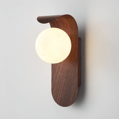 Nordisk vägglampa med träinspirerad stomme och rund glasglob för varm och mjuk belysning