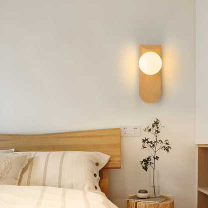 Nordisk vägglampa med träinspirerad stomme och rund glasglob för varm och mjuk belysning